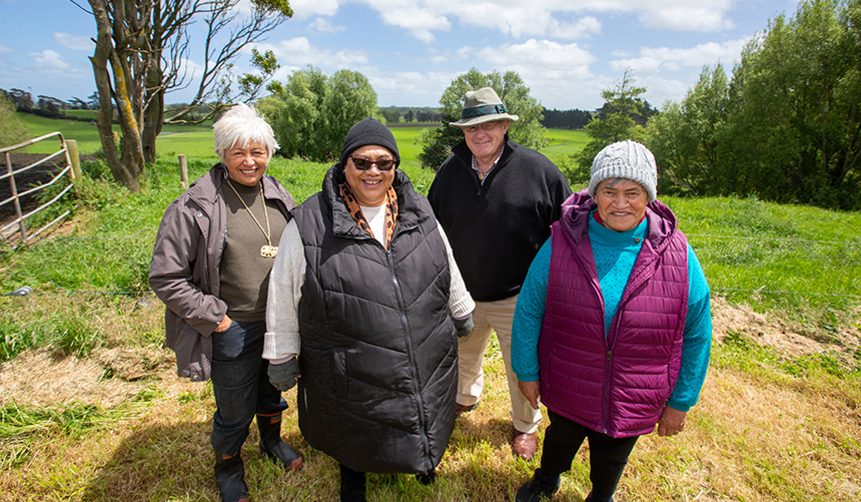 4 people standing outside in a field